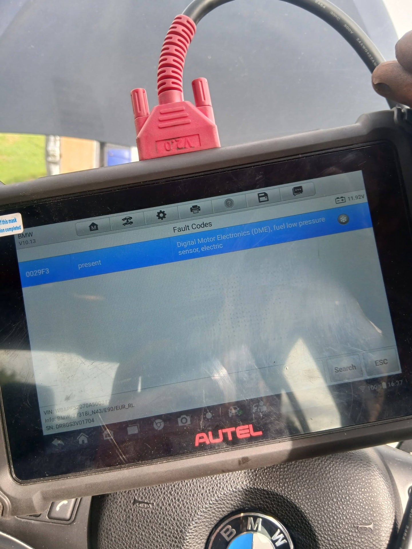 Diagnostic tablet connected to a BMW showing a stored fuel pressure sensor fault code